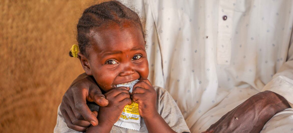 Un enfant réfugié soudanais en train de consommer des compléments alimentaires
