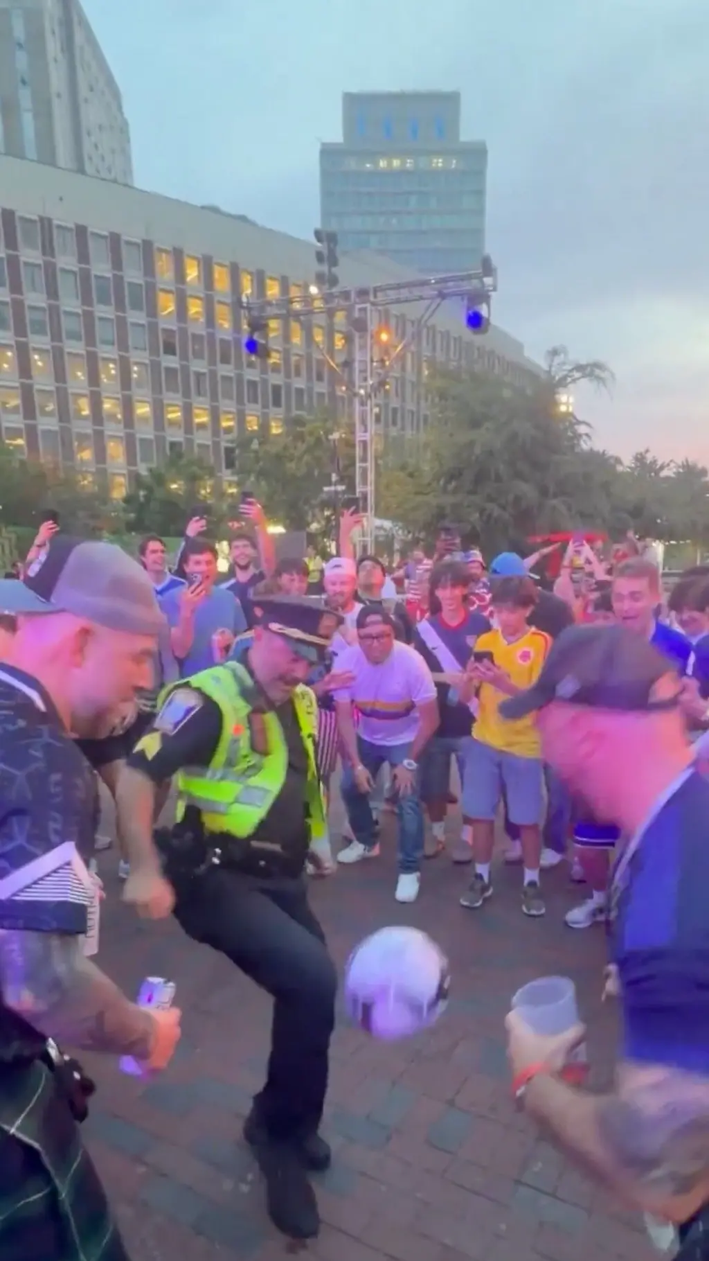 Policier qui jongle dans une foule supporters