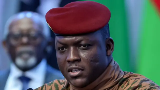 Portrait du capitaine Ibrahim Traoré, vêtu d'une tenue militaire beige et d'un béret rouge.