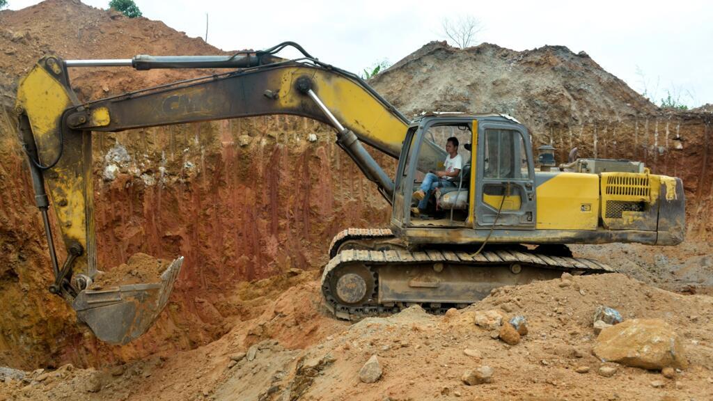 Un employé chinois d'une société minière conduit un bulldozer sur un site d'extraction d'or à Betare Oya, Cameroun, en avril 2018.